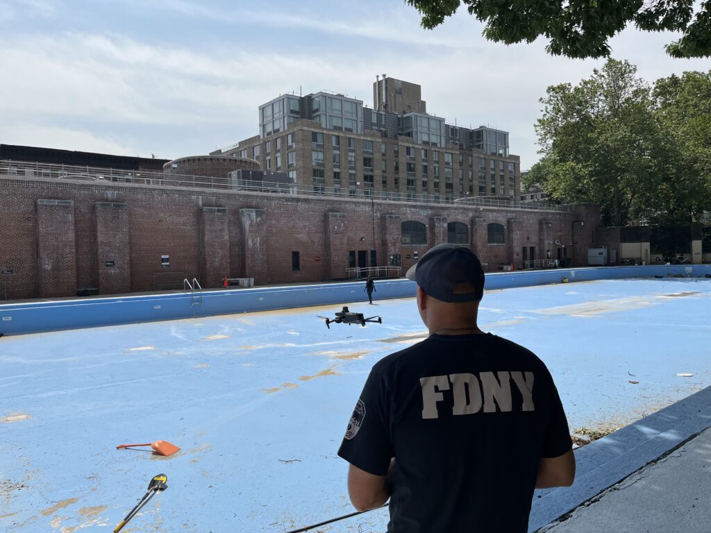 Image of an FDNY employee flying a drone at the Jackie Robinson Recreational Center